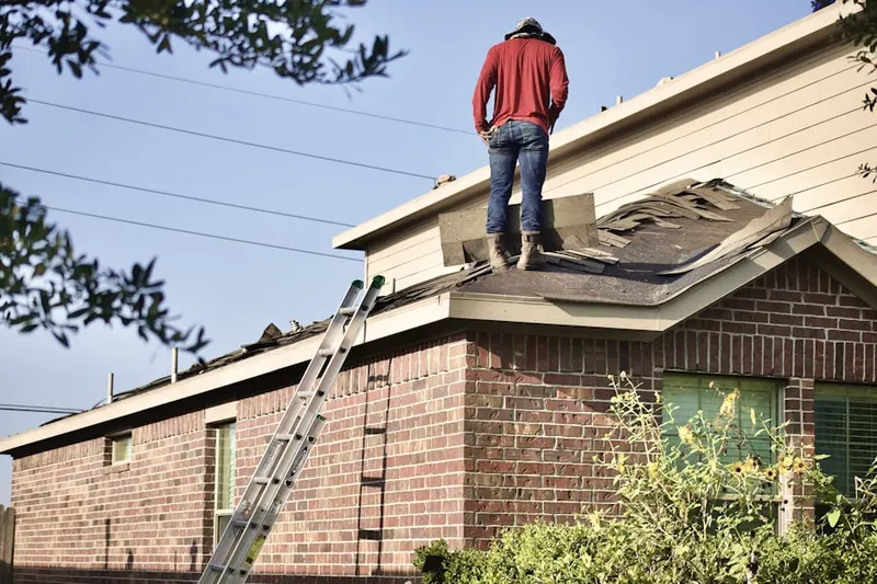 Professional roofer working on a residential roof in Oradell